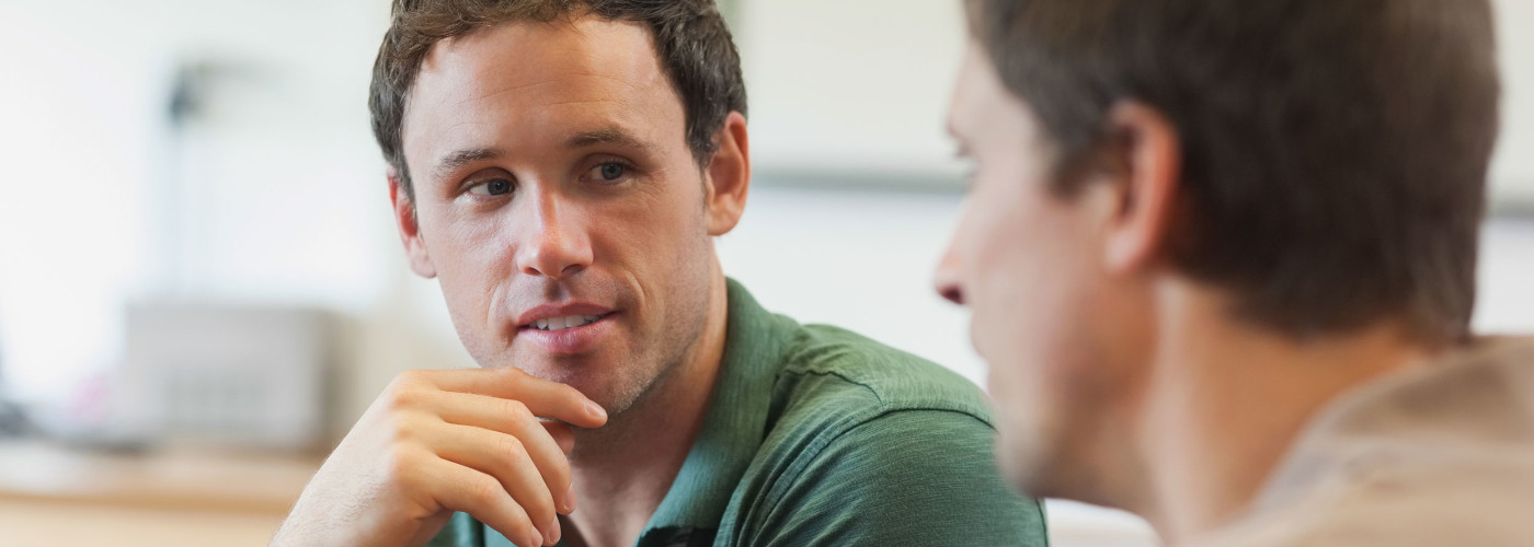 Zwei Männer unterhalten sich angeregt miteinander.  