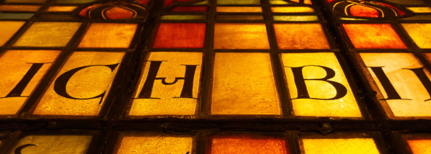 Nahaufnahme eines farbigen Glasfensters mit den Worten "ICH BIN"