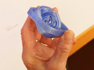 Eine Hand hält ein blaues, spiralförmiges Objekt aus Kunststoff mit mehreren Schichten.