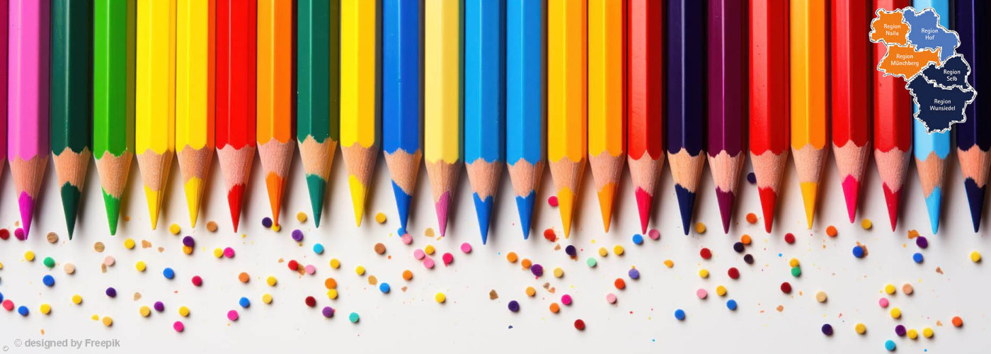 Reihe bunter Buntstifte mit angespitzten Spitzen und verstreuten Farbstückchen darunter